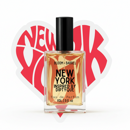 A bottle of Bloom + Barrel New York Inspired By Diptyque Eau de Parfum with a black cap and clear glass showing golden liquid, centered in front of a red heart-shaped New York graphic on a white background.