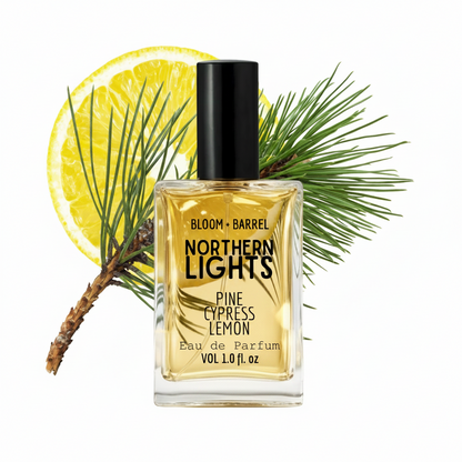 Bottle of 'Northern Lights' perfume with a lemon and pine branch on a white background