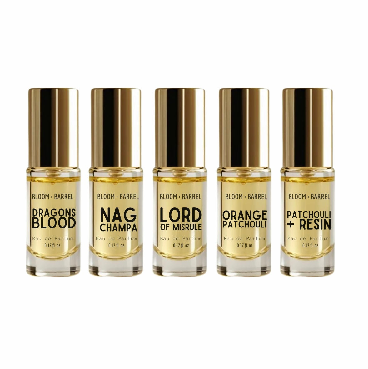 Five small perfume bottles with gold caps arranged in a row on a white background. The labels read BLOOM + BARREL and the scents Dragons Blood, Nag Champa, Lord of Misrule, Orange Patchouli, and Patchouli + Resin.