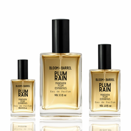 Three bottles of Bloom + Barrel Plum Rain Mandarin Plum Osmanthus Eau de Parfum on a white background