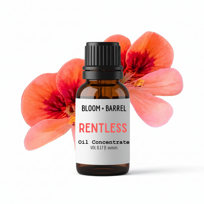 Bottle of 'Rentless' oil concentrate by Bloom & Barrel with pink flowers in the background