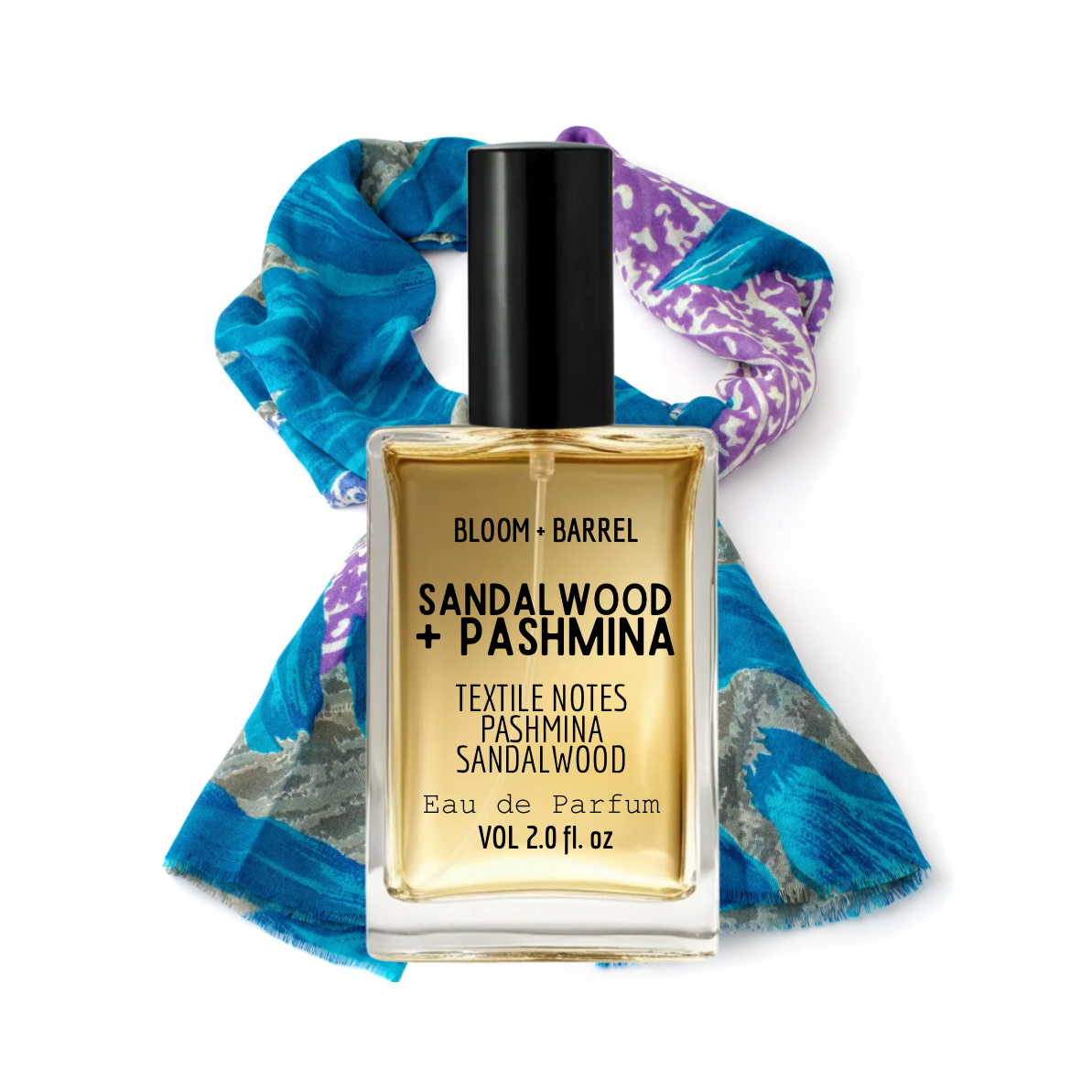 Perfume bottle labeled 'Sandalwood + Pashmina' with a colorful scarf in the background