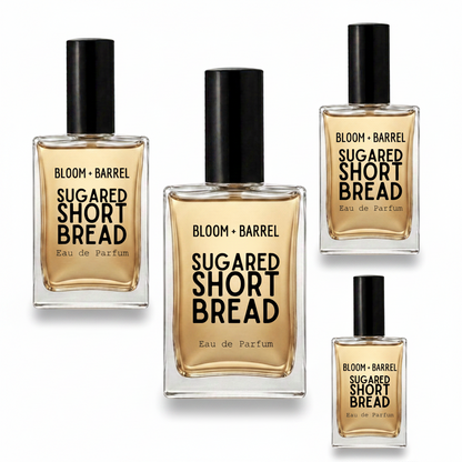 Four glass perfume bottles of BLOOM + BARREL Sugared Short Bread Eau de Parfum with black caps, arranged on a plain white background.