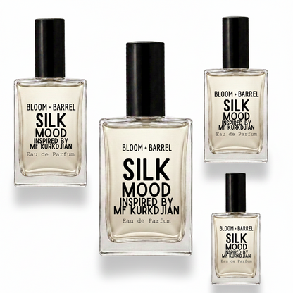 Four glass bottles of Bloom + Barrel Silk Mood Eau de Parfum in different sizes, arranged on a plain white background. The bottles contain a pale golden liquid and are topped with black caps, featuring black text on the front labels.