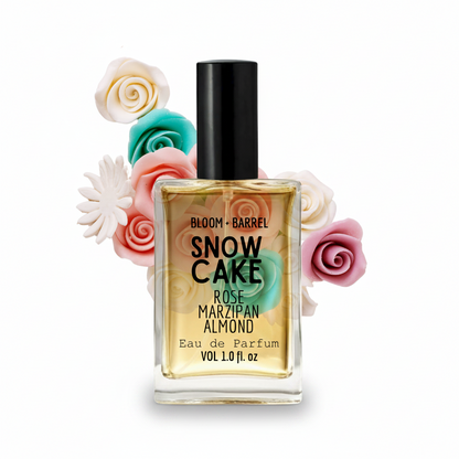 Perfume bottle labeled 'Snow Cake' with decorative flowers on a white background