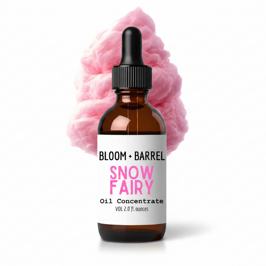 Bottle of Bloom + Barrel Snow Fairy oil concentrate with pink cotton candy in the background