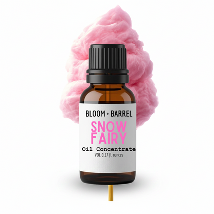 Bottle of Bloom & Barrel Snow Fairy oil concentrate with pink cotton candy in the background