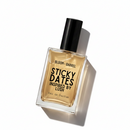 A bottle of Bloom + Barrel Sticky Dates Inspired by Lush Eau de Parfum, featuring a clear glass bottle with amber-colored liquid, a black cap, and bold black text on the front, set against a plain white background.
