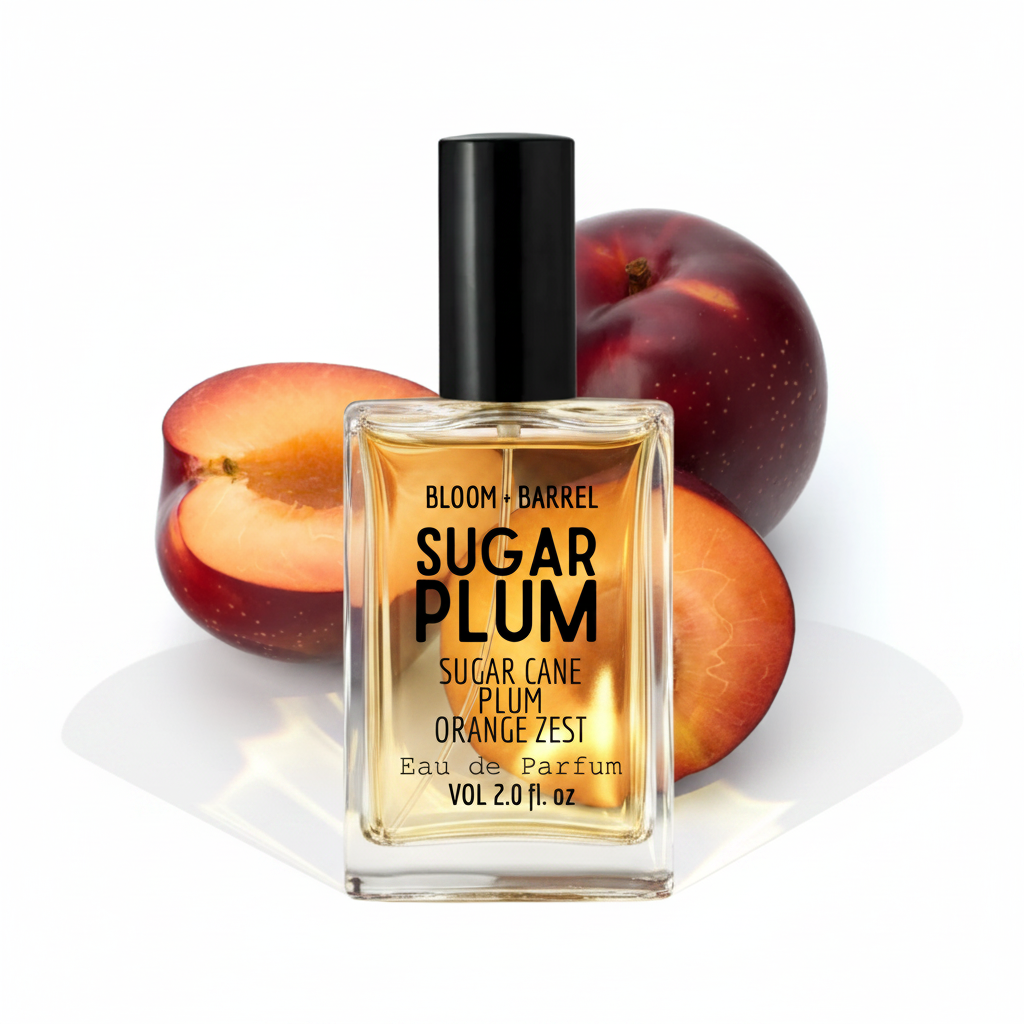 A bottle of Bloom + Barrel Sugar Plum Eau de Parfum with a black cap and clear glass, set against sliced and whole plums on a white background.