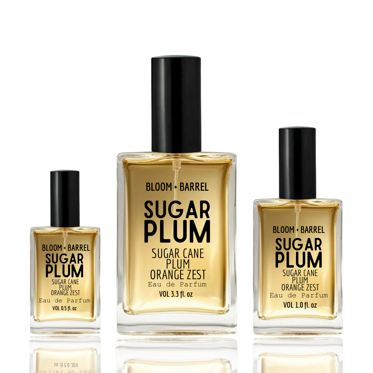 Three bottles of BLOOM + BARREL sugar plum Eau de Parfum in different sizes, arranged on a reflective white surface against a white background.
