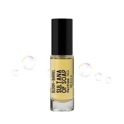 Perfume bottle labeled 'Sultana of Soap' with soap bubbles on a white background