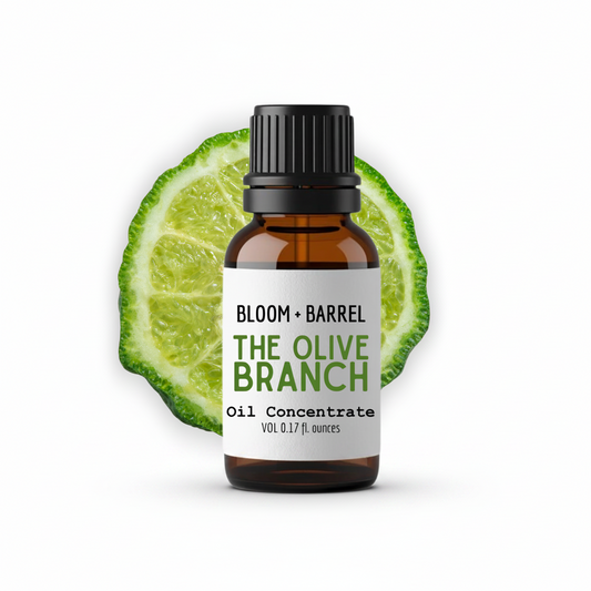 Bottle of 'The Olive Branch' oil concentrate with a lime wedge on a white background