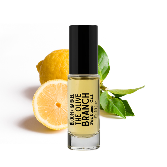 Perfume bottle labeled 'The Olive Branch' with lemons and leaves on a white background