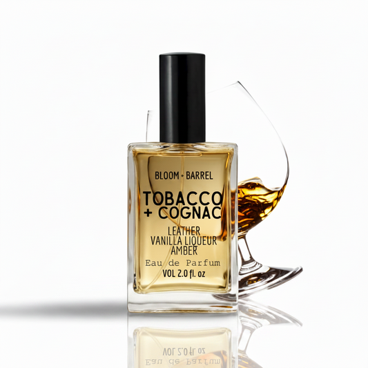 Bottle of Bloom & Barrel Tobacco + Cognac perfume with a glass of cognac on a white background