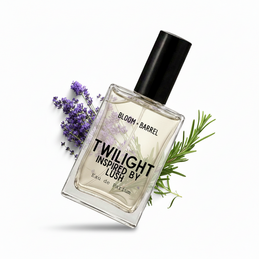 A bottle of Bloom Barrel Twilight Inspired by Lush Eau de Parfum with a black cap, set against a white background and styled with purple lavender and green rosemary sprigs.