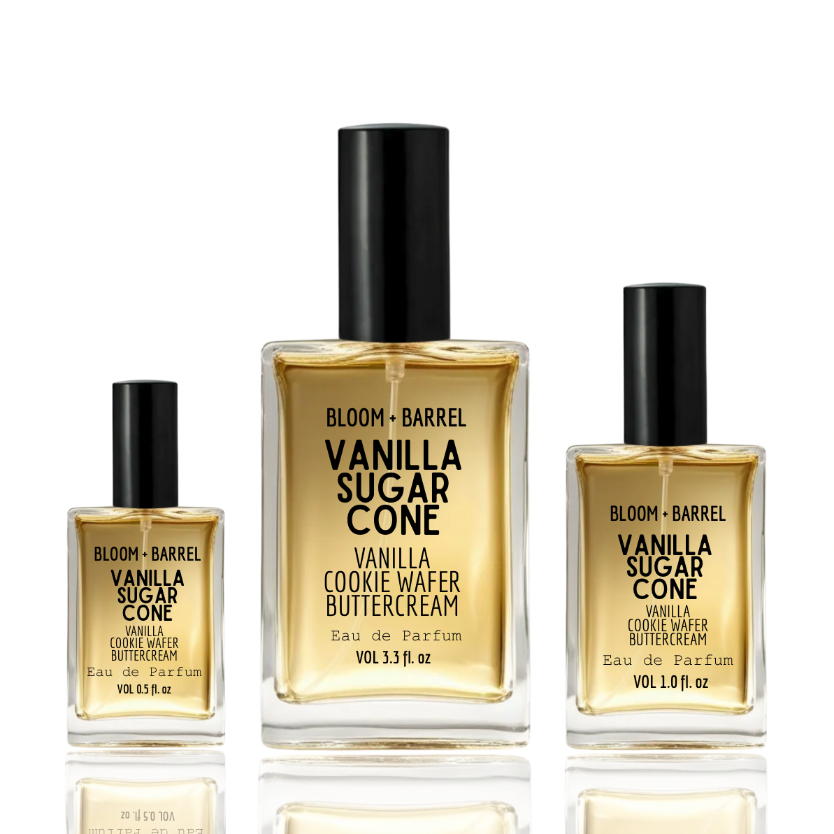 Three clear glass perfume bottles with black caps from BLOOM + BARREL, arranged from smallest to largest on a white reflective surface. The center bottle is larger and labeled Vanilla Sugar Cone, flanked by two smaller Vanilla Cookie Wafer Buttercream bottles.