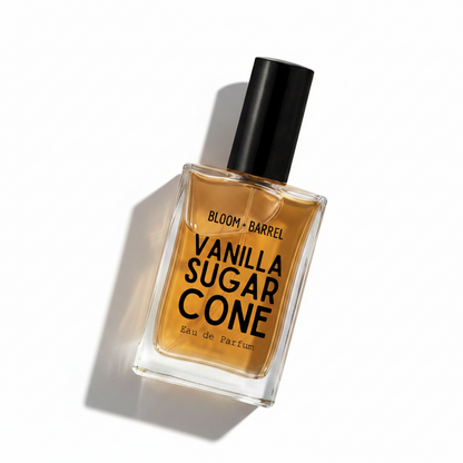 A rectangular glass bottle of Bloom Barrel Vanilla Sugar Cone Eau de Parfum with amber-colored liquid, a black cap, and bold black lettering on a clean white background.