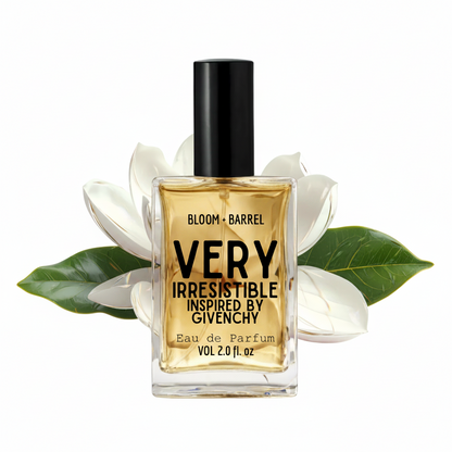 A bottle of Givenchy Bloom + Barrel Very Irresistible Eau de Parfum, featuring a clear glass bottle with a black cap and golden-amber liquid, styled with white magnolia flowers and green leaves on a white background.
