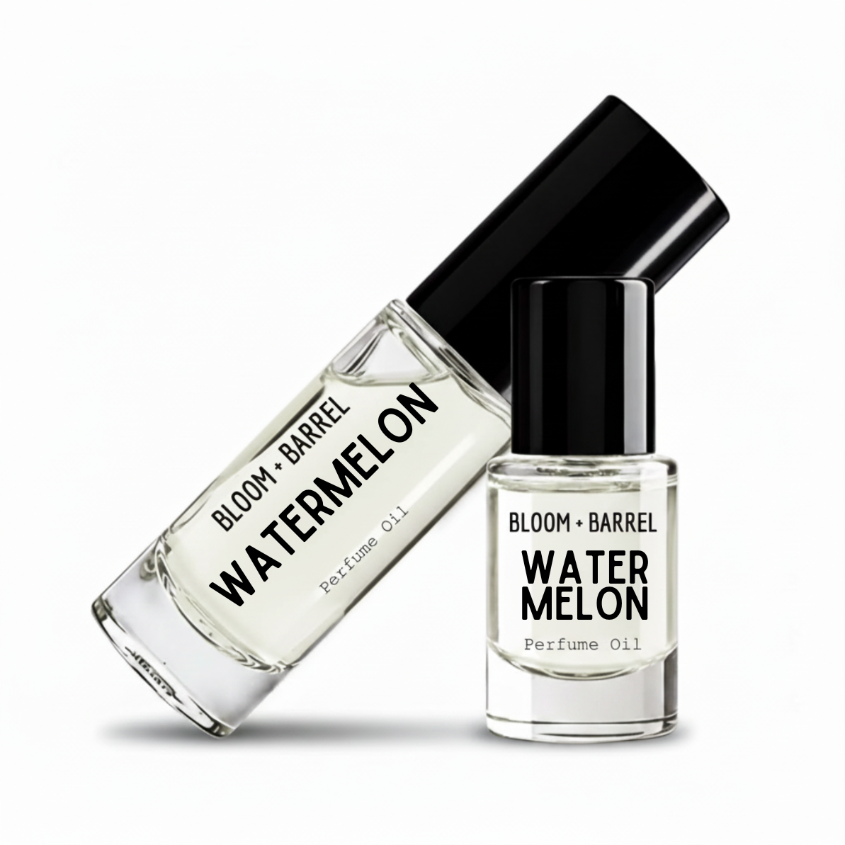 Two clear glass perfume oil bottles with black caps on a white background. One bottle is tilted diagonally and reads 'BLOOM + BARREL WATERMELON Perfume Oil,' while the other stands upright with the same label.