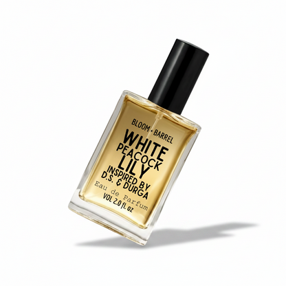 A rectangular glass perfume bottle with a black cap, filled with amber-colored fragrance liquid. The front label reads 'BLOOM + BARREL' and 'WHITE PEACOCK LILY